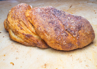 Wicker bun with cinnamon and sugar. Bread product of an unusual shape. Homemade baking. Buns with a ruddy crust.