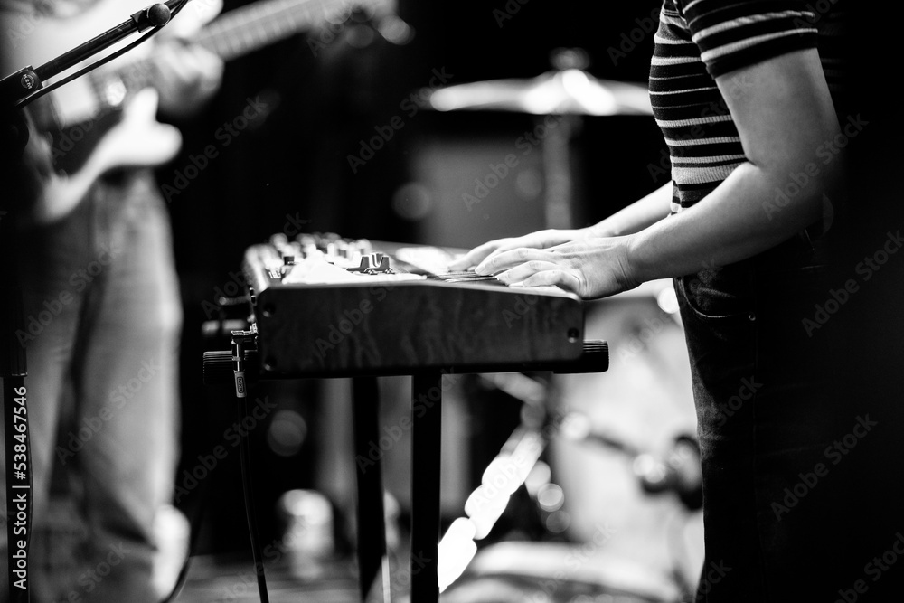 Wall mural Band playing music and a gig in a venue, close up of a rock band playing guitars and instruments.