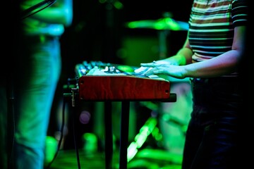 Band playing music and a gig in a venue, close up of a rock band playing guitars and instruments.
