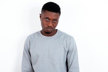 young handsome man wearing grey sweater over white background depressed and worry for distress, crying angry and afraid. Sad expression.