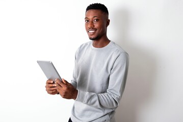 Photo of optimistic young handsome man wearing grey sweater over white background hold tablet