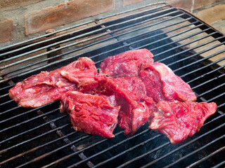 Raw meat on the barbecue grill. Cooking outside.