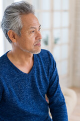 部屋でリラックスするシニア男性