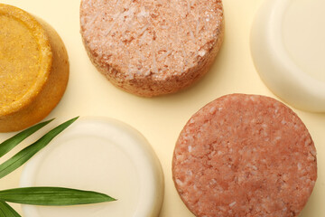 Flat lay composition of solid shampoo bars and leaf on beige background. Hair care
