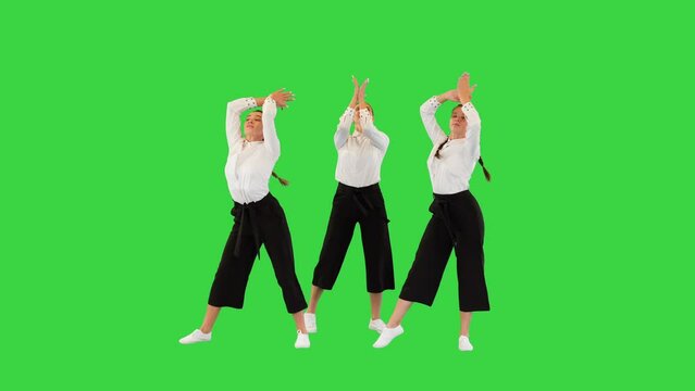 Three stylish female dancers in white shirts walk in, dance and walk away on a Green Screen, Chroma Key.