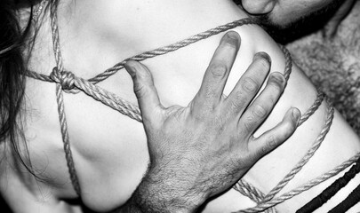 A young, slim, naked hot woman with knots of natural ropes kissed by her boyfriend. Ancient...