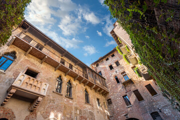 Fototapeta na wymiar View of Juliet's balcony and house, a Gothic-style 1300s house and museum, with a stone balcony, said to have inspired Shakespeare, in Verona, Italy.