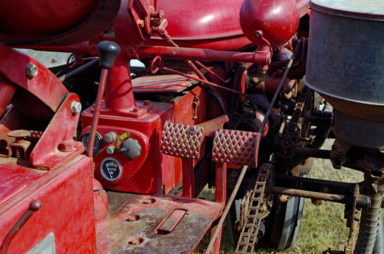 Driver's seat view of gauges and controls on vintage red  farm tractor