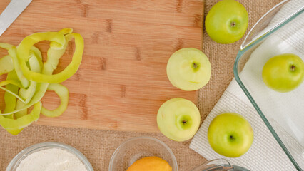 Apple cake with biscuit base recipe. Peeled green apples close up on a wooden board