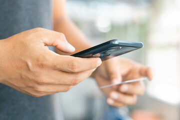 Closeup of hand man paying and shopping with a smartphone application. Mobile payment with wallet app technology. Digital money transfer, banking and e-commerce concept.