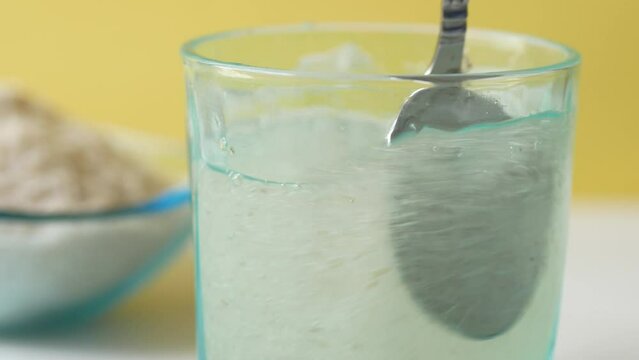 spoon stirring Psyllium Seeds in a glass 