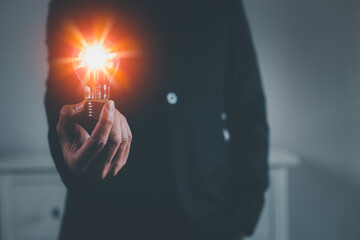 Businessman hand holding a bright light bulb. Concept of Ideas for presenting new ideas Great inspiration and innovation new beginning.