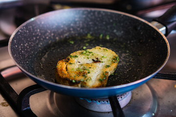 Fried bread with condiments in a frying pan, no people. Food.
