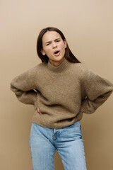 a frustrated, loudly screaming woman looks into the camera standing in an aggressive pose with her hands on her belt. Vertical Studio Photography