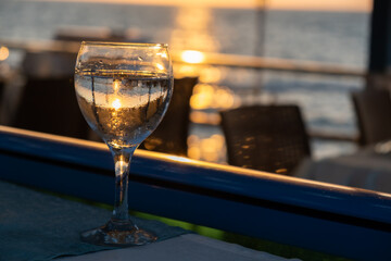 Glass of white wine at sunset near seaside with copy space