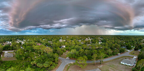 Landscape of dark ominous clouds forming on stormy sky during heavy thunderstorm over rural town...