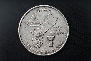 Old scratched Guam United States Quarter Dollar Coin on wooden table