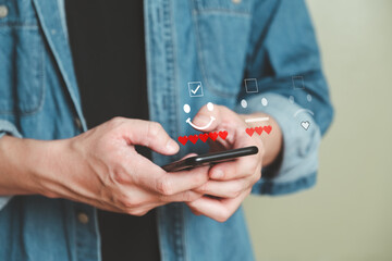 Selective focus at human hand while typing on laptop or smartphone to feedback on excellent customer service with five heart score with smile. Service evaluation concept with futuristic icon.