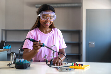 Teenager black girl high school student in class learning electronics. Copy space.Education