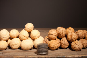 Walnut and silver coins. Nuts on a wooden table.