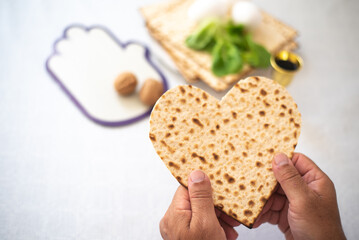 Man's hands holds Matzah shape of heart. Traditional of Jewish Holiday on Passover. Home symbol of lovely family. top view, layout. love and care. Gift for lovers. Feeling in love and blissful life