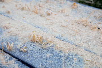Woog shavings after planing beams and borders lying on gray wooden boards