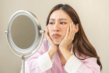 Dermatology, expression face worry asian young woman looking mirror hand touch facial at dark spot...