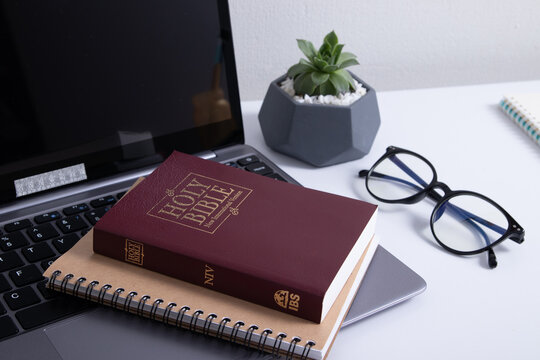 Bible And Laptop On The Work Table With Glasses. Holy Bible Study Online