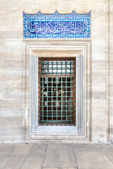 Fototapeta na wymiar Decorated wrought iron window, in a stone wall, at the courtyard of Suleymaniye Mosque, Istanbul, Turkey
