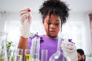 Lovely school girl excited to do a science experiment in science laboratory classroom.