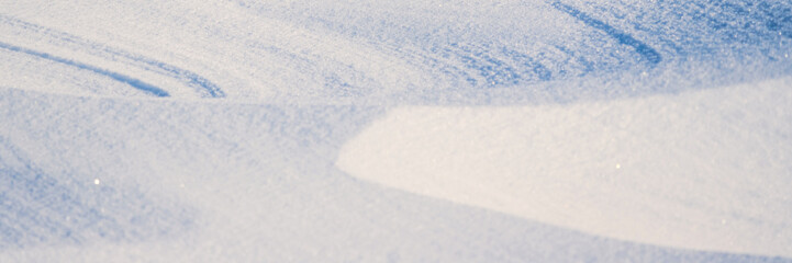 Fototapeta na wymiar Beautiful winter background with snowy ground. Natural snow texture. Wind sculpted patterns on snow surface. Arctic, Polar region.