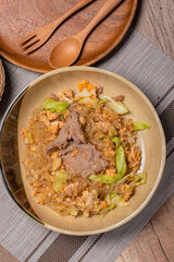 Stir fried vermicelli with pork, egg and collard greens in a white plate.