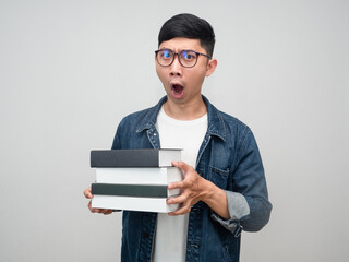 Asian man businessman wear glasses holding the books feels amazed isolated