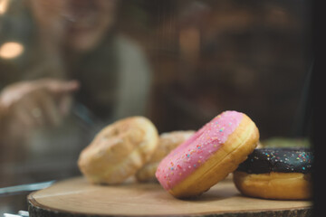 waitress looking at bakery and choose a bread for customer order. the happiness woman in bakery shop on waiter uniform and service customer.