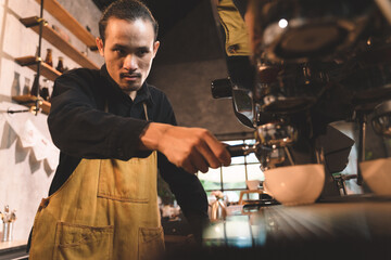 portraits of happiness two waiter teaching woman with apron to use a coffee machine for make a coffee. the happiness men and woman in bakery small business on waiter and waitress uniform.
