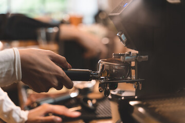 coffee beans ground and coffee powder pouring into holder with coffee machine at a cafe into coffee cup. Coffee machine and coffee bean in a cafe and restaurant counter.