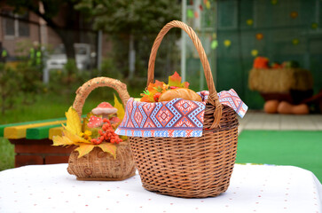 Autumn composition baskets with autumn leaves and berries stand on a white table