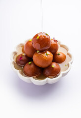 Gulab jamun or gulabjamun is an Indian sweet, served in a bowl as pile. closeup view