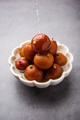 Gulab jamun or gulabjamun is an Indian sweet, served in a bowl as pile. closeup view