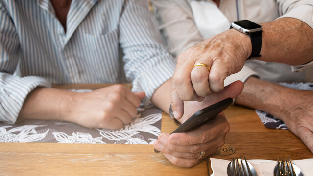 Close-up of  Elegant senior man hands using smartphone together