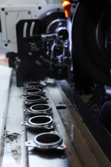 Plakat Manufacture of bearings. Details of new bearings on the machine. Concept of the industrial industry. Selective focus. Vertical photo.Harmful production.