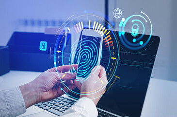 Businessman with smartphone and laptop, fingerprint hologram on screen