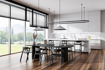 Light kitchen interior with dining area and countertop, panoramic window