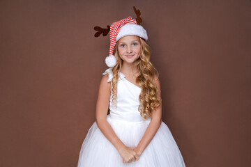 Obraz na płótnie Canvas Photo funny curly girl dreaming that Christmas will bring peace and love to all people on earth looking for an empty space, wearing headdress with horns, concept christmas and new year on background
