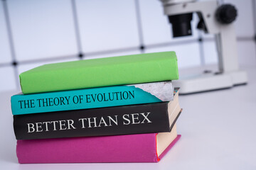 Stack of books with titles making up text.The theory of evolution is better than sex