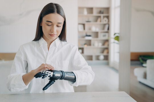 Girl adjust settings of bionic prosthetic arm, touch sensory panel on upper side of artificial hand