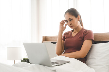 Young adult asian woman using laptop on bed for telemedicine mental health online therapy