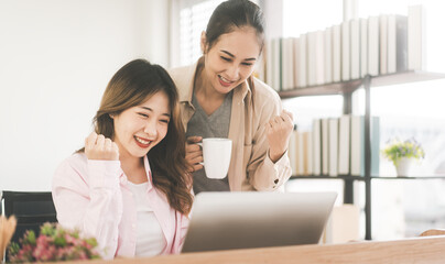 Two young adult asian woman couple at home using laptop for shopping online and work