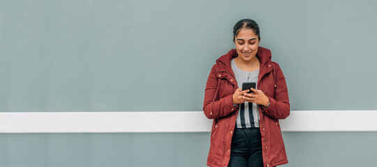 young woman with mobile phone in the street with copy-space