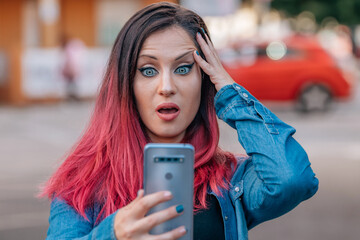 amazed woman on the street with mobile phone